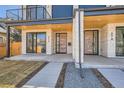 Close-up of a modern duplex exterior with wood doors, stone accents, and manicured lawns at 372 S Humboldt St, Denver, CO 80209