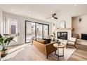 Bright living room featuring a modern fireplace, tan leather couch, and seamless outdoor access at 372 S Humboldt St, Denver, CO 80209