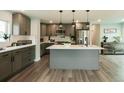 This spacious kitchen features gray cabinets, a large island with a sink, and stainless steel appliances at 1450 Syracuse St, Denver, CO 80220
