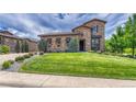 Charming stone home with well-manicured lawn and mature landscaping at 9343 Vista Hill Ln, Lone Tree, CO 80124