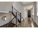 Elegant foyer showcasing beautiful hardwood floors, staircase with iron balusters, and stylish lighting at 9343 Vista Hill Ln, Lone Tree, CO 80124