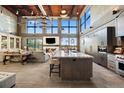 Spacious living area with soaring ceilings, exposed brick, fireplace, and chef's kitchen with island seating at 367 Sandy Hollow Trl, Franktown, CO 80116