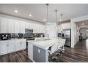 Modern kitchen featuring stainless steel appliances, sleek white cabinetry, and a spacious island at 15788 Xanthia Way, Thornton, CO 80602