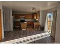 Open-concept kitchen boasts wood cabinets, an island, and access to the deck at 2746 E 132Nd Pl, Thornton, CO 80241