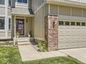 Inviting home entrance with a charming brick pillar, address display, and a well-maintained lawn at 7659 Lebrun Ct, Lone Tree, CO 80124