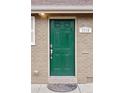 Close-up of the front door with a green finish and decorative number plate set in a brick facade at 3715 Wolff St, Denver, CO 80212