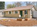 Charming brick home featuring a well-maintained front yard with planters and a cozy seating area near the entrance at 3715 Wolff St, Denver, CO 80212