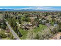 Scenic aerial view of a home nestled among mature trees with mountain views in the distance at 4480 S Franklin St, Cherry Hills Village, CO 80113