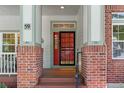 Inviting front porch with brick columns, house number 59, and a decorative front door with a storm door at 6900 W Grant Ranch Blvd # 59, Littleton, CO 80123