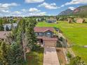 Beautiful home with mountain views, featuring a long driveway and mature trees at 133 Wheat Ridge St, Palmer Lake, CO 80133