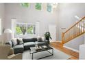Bright living room featuring a large sectional sofa, high ceilings, and hardwood floors at 14625 Vine St, Thornton, CO 80602