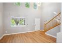 Bright living room with high ceilings, large windows, hardwood floors, and wooden stairs at 14625 Vine St, Thornton, CO 80602