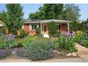 Inviting brick home with a well-manicured lawn and colorful flower beds enhancing its curb appeal at 3380 S Ogden St, Englewood, CO 80113