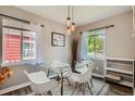 Bright dining room featuring a glass table, modern chairs, and elegant pendant lighting at 1309 Jamaica St, Aurora, CO 80010