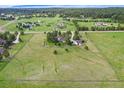 Sprawling property featuring a home, outbuildings, and vast fenced green fields under a blue sky with scattered clouds at 497 Grey Squirrel Way, Franktown, CO 80116