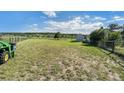 Spacious green backyard with a barn and fenced with an agricultural tractor for property maintenance at 497 Grey Squirrel Way, Franktown, CO 80116
