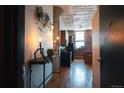 Hallway view showcasing a kitchen with stainless steel appliances and exposed brick at 2261 Blake St # 5H, Denver, CO 80205