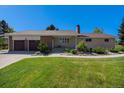 Charming single-story home with brick and stone accents, lush lawn, and a two-car garage at 90 Ammons St, Lakewood, CO 80226