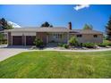 Charming single-story home with brick and stone accents, lush lawn, and a two-car garage at 90 Ammons St, Lakewood, CO 80226