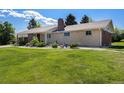 Charming single-story home with brick and stone accents, lush lawn, and a well-kept yard at 90 Ammons St, Lakewood, CO 80226