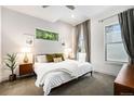 Bright bedroom with neutral tones, a large window with green foliage, and stylish mid-century modern furniture at 2103 W 32Nd Ave # 10, Denver, CO 80211