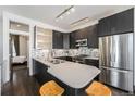 Modern kitchen with dark cabinets, stainless steel appliances, and a quartz countertop island with bar seating at 2103 W 32Nd Ave # 10, Denver, CO 80211