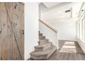 Entryway with wooden barn door, staircase, and hardwood floors at 18639 E 50Th Pl, Denver, CO 80249