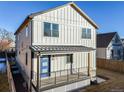Modern farmhouse exterior, featuring gray siding and a blue door at 3880 Sheridan Blvd, Denver, CO 80212
