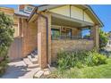 A close-up of a brick home's porch with brick pillars, railing and green lawn at 4545 King St, Denver, CO 80211