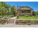Brick home featuring stone retaining wall, manicured lawn and a pathway leading to the front door at 4545 King St, Denver, CO 80211