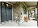 Covered front porch with stone accents, a bench, and plenty of room to relax and enjoy the outdoors at 2077 S Clayton St, Denver, CO 80210