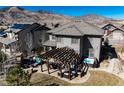 Aerial view of a backyard featuring a patio, pergola, hot tub, and beautiful mountain views at 15798 Weaver Gulch Dr, Morrison, CO 80465