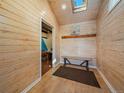 Inviting entryway with light wood paneling, bench seating, and skylight at 30858 Niakwa Rd, Evergreen, CO 80439