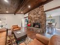 Cozy living room with a stone fireplace, wood ceiling, and comfortable seating at 30858 Niakwa Rd, Evergreen, CO 80439
