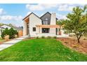 Beautifully landscaped front yard featuring a modern home with white brick and black accents on a lush green lawn at 1685 S Milwaukee St, Denver, CO 80210