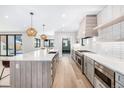 Spacious kitchen with a large center island, modern appliances, light wood floors, and pendant lighting at 1685 S Milwaukee St, Denver, CO 80210