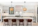 Bright, modern kitchen featuring white subway tile, a large island with seating, and stylish pendant lighting at 1685 S Milwaukee St, Denver, CO 80210