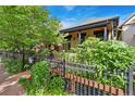 Street-side exterior shot with garden, decorative iron fence, and great curb appeal at 3313 Curtis St, Denver, CO 80205