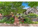 Charming home exterior featuring lush landscaping, a walkway, and a decorative fence at 3313 Curtis St, Denver, CO 80205
