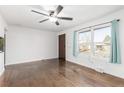 Bright living room featuring hardwood floors, fresh paint, ceiling fan and a large window providing ample natural light at 1591 S Zuni St, Denver, CO 80223