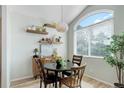 Cozy dining area with a round table, modern light fixture, and a large window offering natural light at 8500 E Jefferson Ave # 3H, Denver, CO 80237