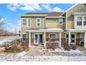 Inviting two-story home featuring a covered porch with decorative lighting and well-maintained landscaping at 11833 Oak Hill Way # E, Commerce City, CO 80640