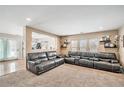 Bright living room featuring plush carpeting, with a large window and comfortable leather sofas at 11833 Oak Hill Way # E, Commerce City, CO 80640