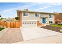 Two-story home with a two car garage and a fenced side yard, with lovely landscaping and a concrete driveway at 2027 S Welch Cir, Lakewood, CO 80228