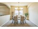 Elegant dining room with arched entryways, chandelier lighting, and large windows at 1404 Tonkin Pl, Longmont, CO 80504