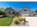 Well-maintained home boasts a three-car garage, beautiful landscaping, and stone accents on the facade at 27235 E Lakeview Pl, Aurora, CO 80016