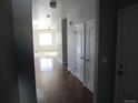 Hallway showcasing hardwood floors and white doors, leading to a room with bright light at 25858 E Bayaud Ave, Aurora, CO 80018