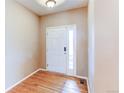 Bright entryway featuring hardwood floors, a white front door with sidelight, and neutral wall paint at 13744 Columbine St, Thornton, CO 80602