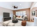 Comfortable living room with a large window, a white sofa, modern decor, and a ceiling fan at 13744 Columbine St, Thornton, CO 80602