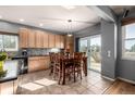 Bright dining area with tile floors, wooden table set, and sliding glass door to the backyard at 291 Las Lomas St, Brighton, CO 80601